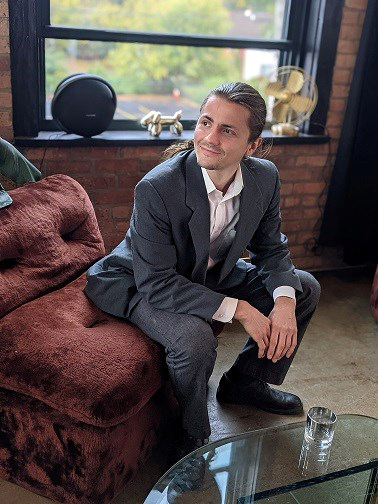 Man in suit sitting on a red velvet chaise